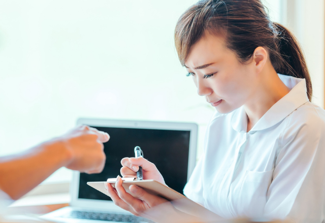 女性職員がクレームを受けている中、真剣にメモを取っている様子